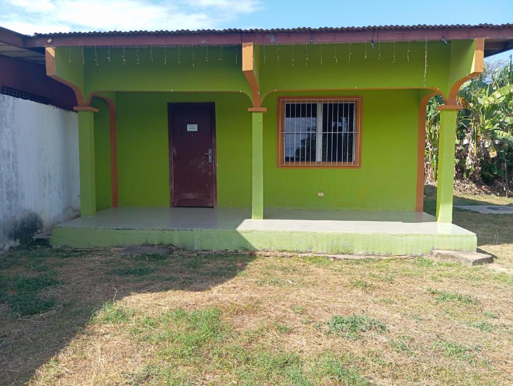 a green house with a door in a yard at Casa de Malle in Pocrí