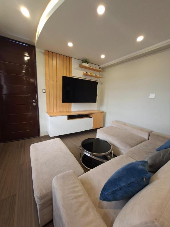 a living room with two couches and a flat screen tv at Beach House - Besso Beach in Barranca