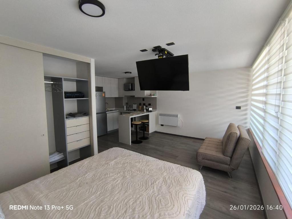 a bedroom with a bed and a television on the wall at Departamento Piso 6 in Puerto Montt