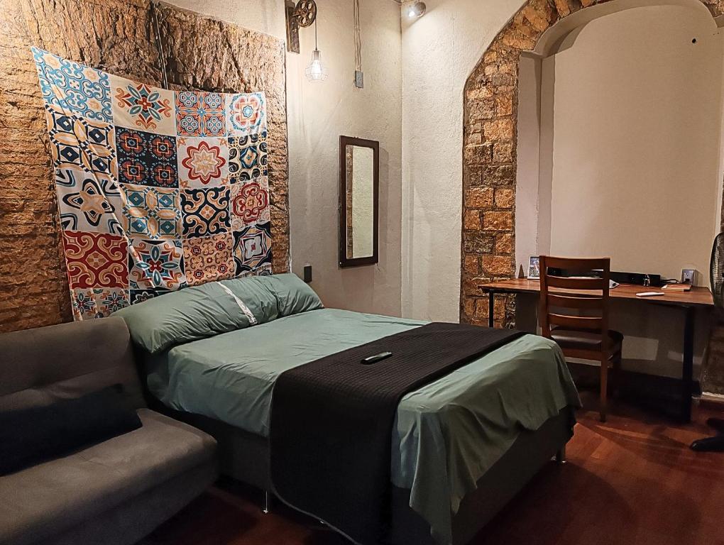 a room with a bed and a couch and a table at Casona Imperial in Tepic