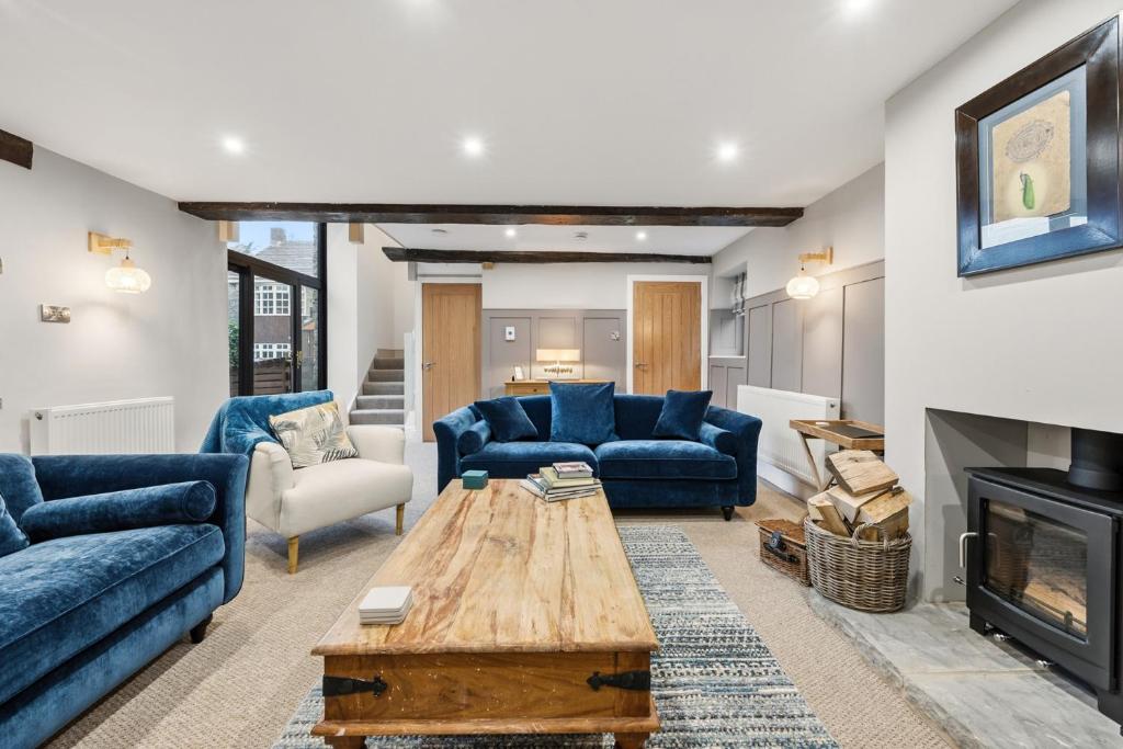 a living room with blue couches and a fireplace at The Forge in Castleton