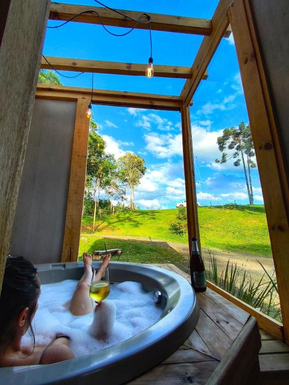 a little girl laying in a bath tub with a view at Chale Pepê in Campo Alegre