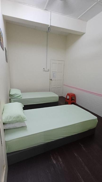 a room with two beds and a red suitcase at POLI Homes in George Town