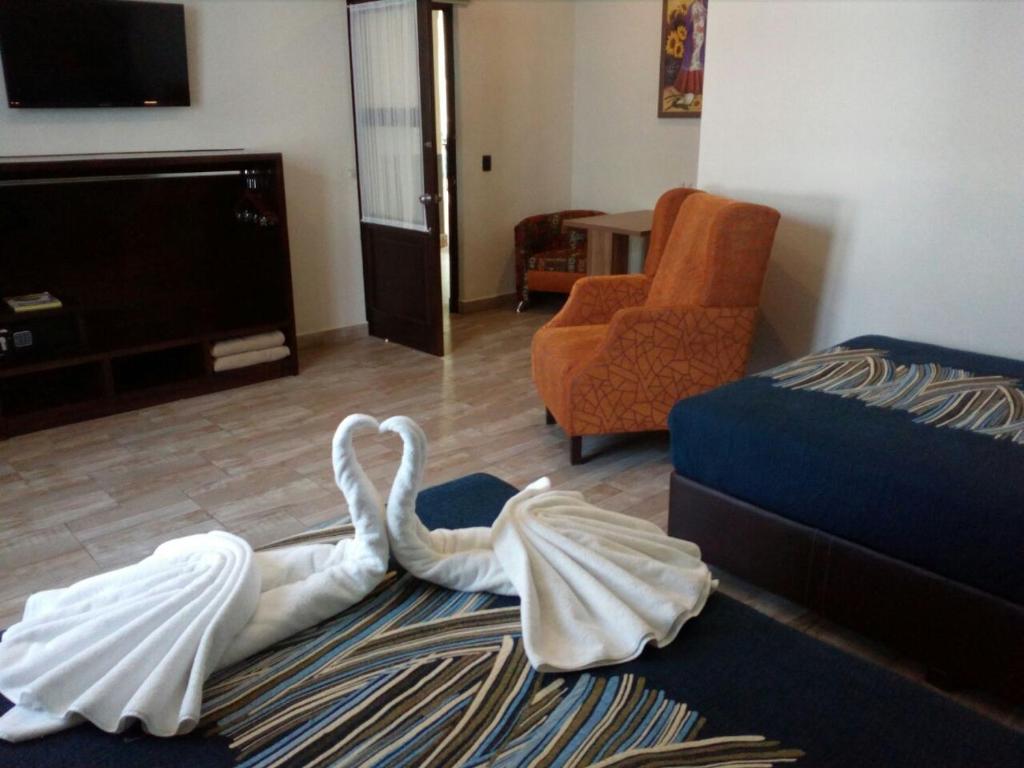 a living room with two swans laying on a rug at Hotel Frida in Puebla