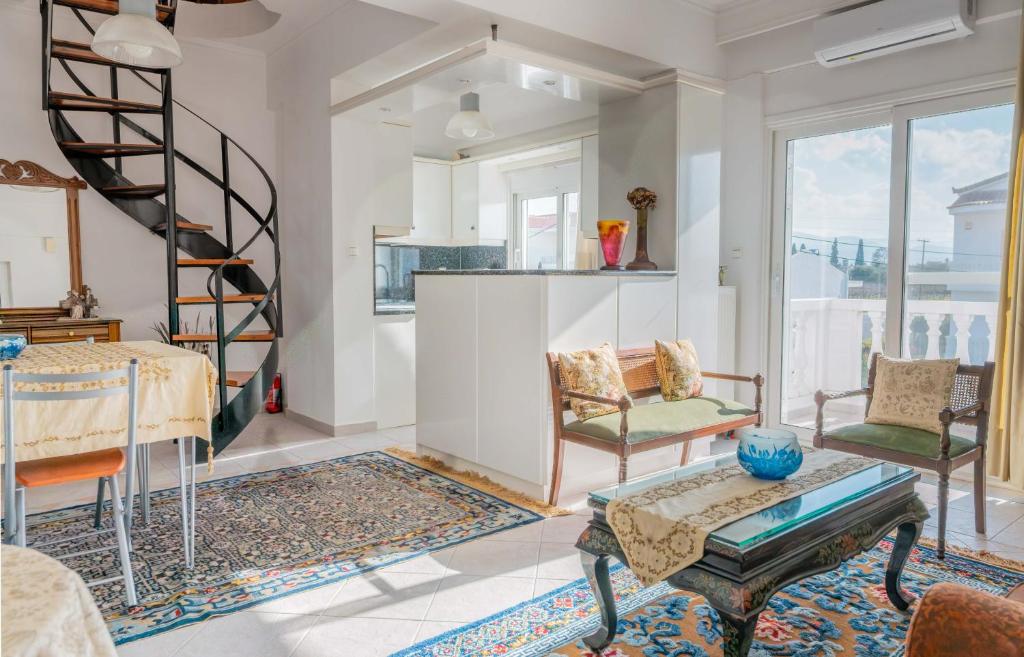 a living room with a spiral staircase and a table at Villa Luna in Káto Ássos