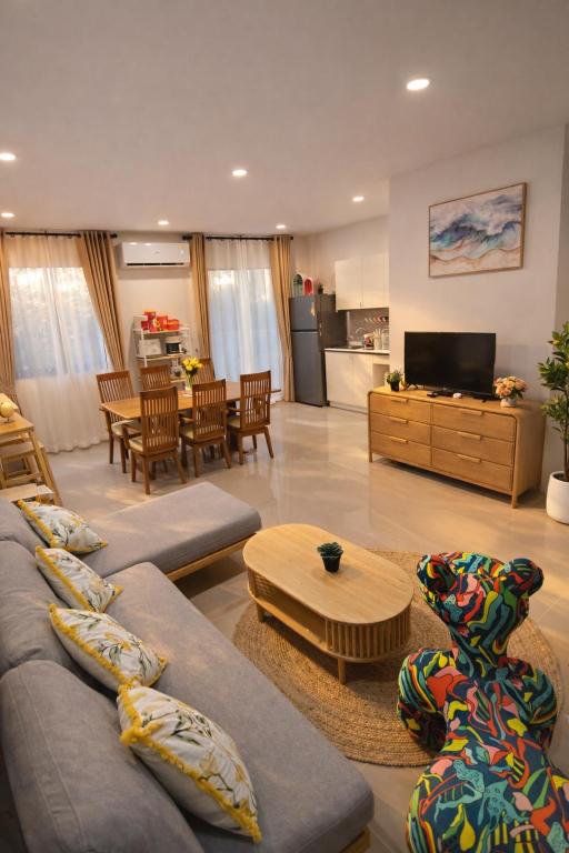 a large living room with couches and a kitchen at Dolce Home suratthani in Suratthani