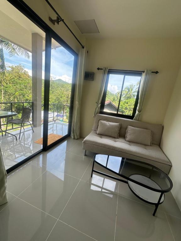 a living room with a couch and a glass table at Mina House in Thong Nai Pan Yai