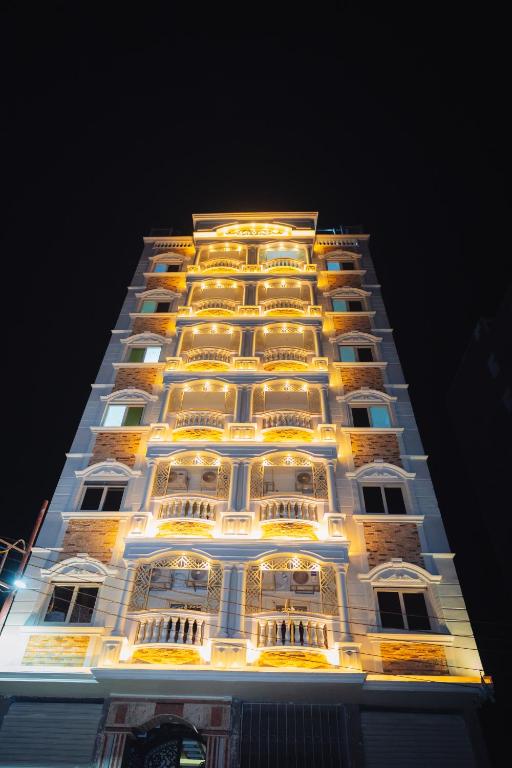 a tall building with lights on it at night at Star Luka in Luxor