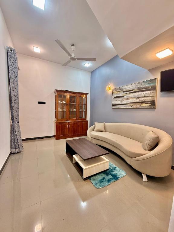 a living room with a couch and a table at Serandib Town Apartment in Weligama