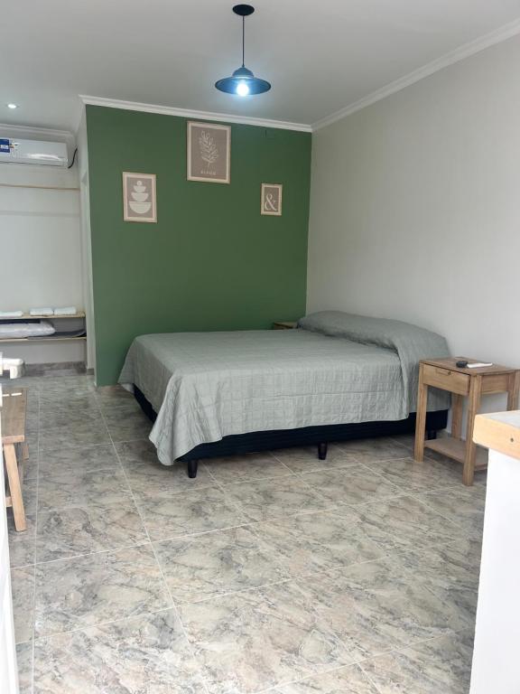 a bedroom with two beds and a green wall at Casa de Aire Ezeiza in La Unión