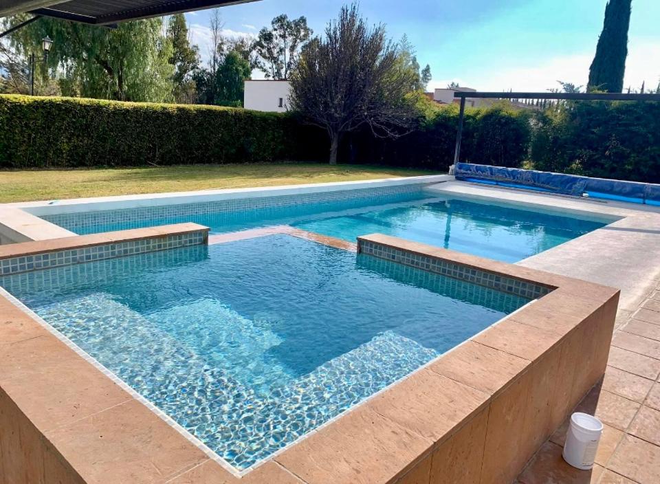 a swimming pool in a backyard with a large pool at Oasis Tequisquiapan in Tequisquiapan