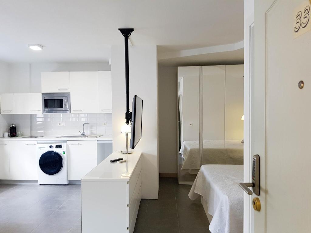 a white kitchen with a washer and dryer at Suites Garden Apartamento 33 in Las Palmas de Gran Canaria