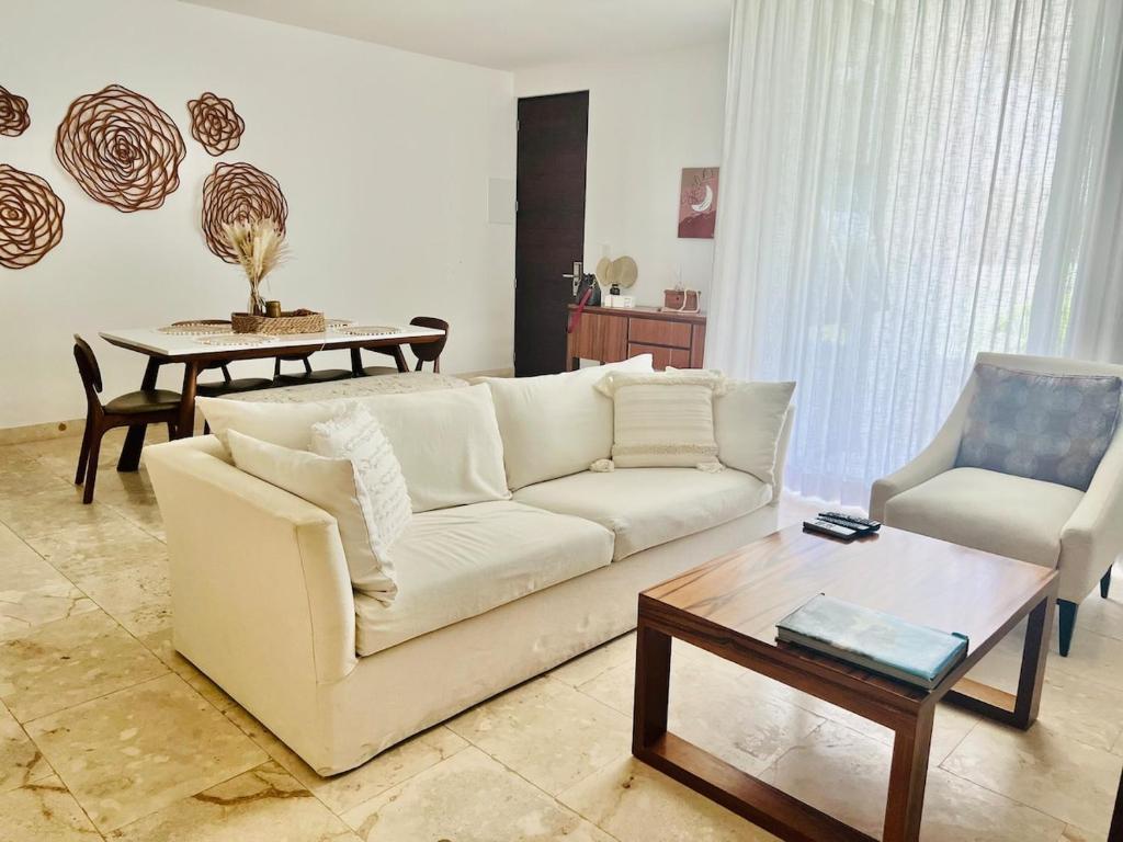 a living room with a white couch and a table at Lux Condo Anah Downtown in Playa del Carmen