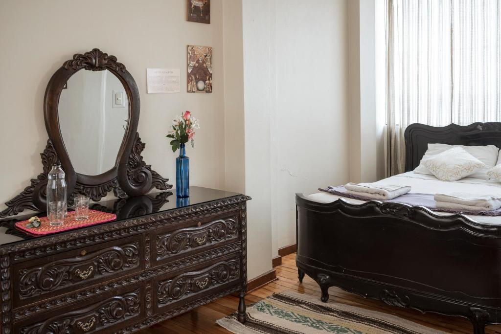 a bedroom with a black dresser and a mirror at Moty's Guesthouse in Cusco