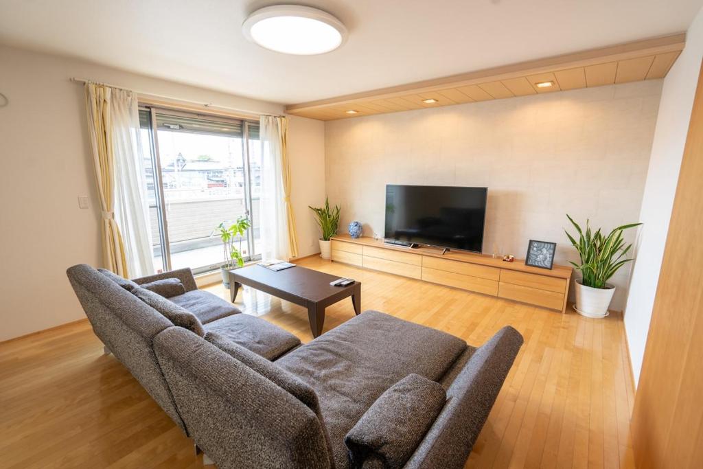 a living room with a couch and a flat screen tv at 絆Kizuna in Yatomi 