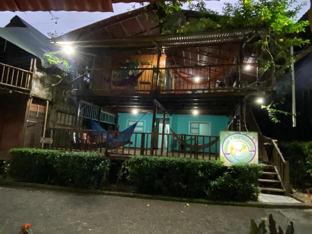 a house with a balcony with a sign on it at Posada Kevelin in Termales - agua caliente - nuqui