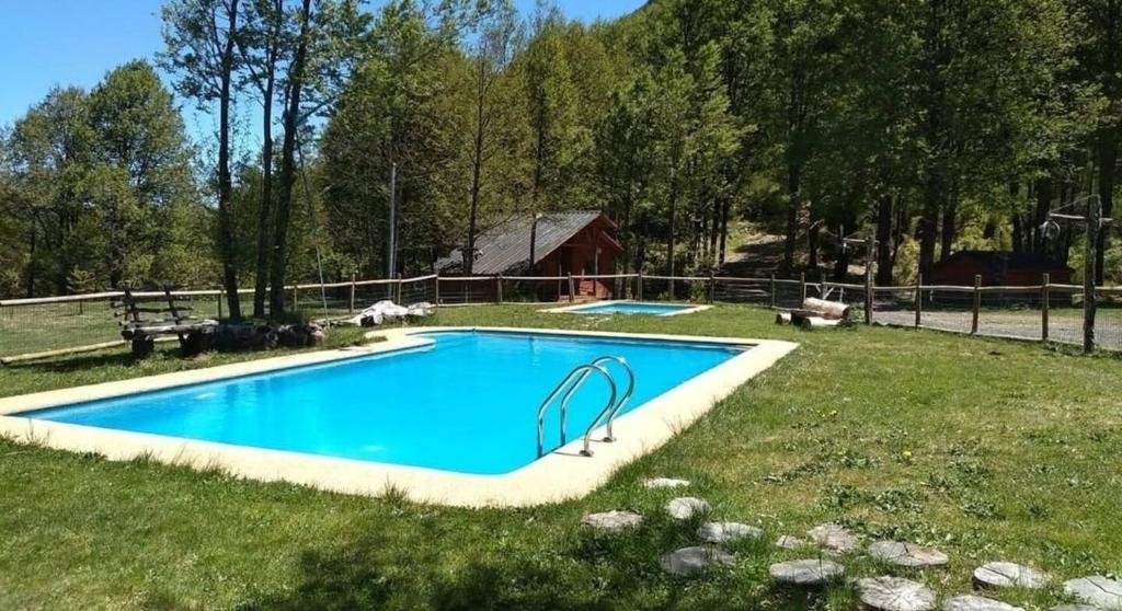 a swimming pool in the middle of a grassy field at Nevisca 5p in Curacautín