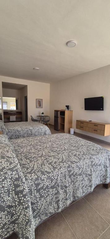 a hotel room with two beds and a flat screen tv at Suites EL FARO San Carlos in San Carlos