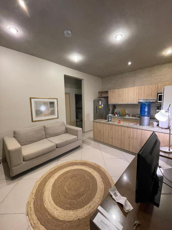 ein Wohnzimmer mit Sofa und eine Küche in der Unterkunft Bloco Escondido in Asunción
