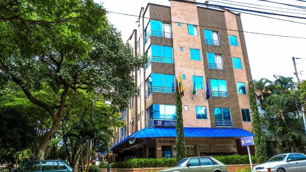 a tall building with blue windows on a street at Living Montes in Medellín