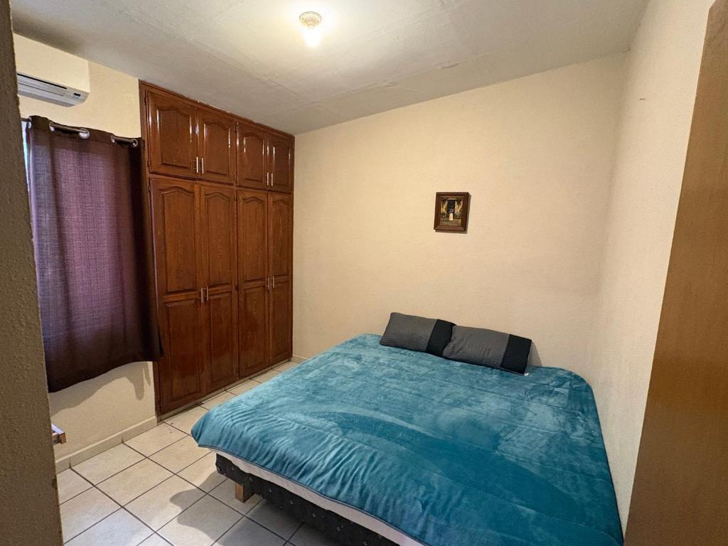 a bedroom with a bed with a blue comforter at Casa compartida de 1 habitación a 10 min de la playa in La Paz