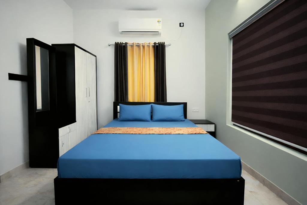 a bedroom with a blue bed with a window at Varkalite homestay in Varkala