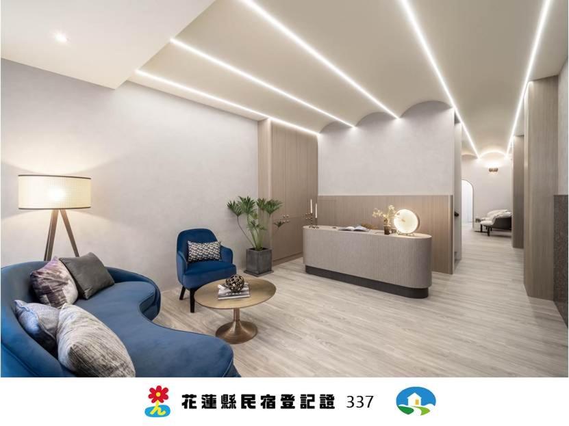 a living room with a blue couch and a table at 日軸蒔光 in Hualien City
