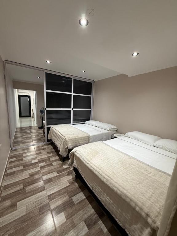 a bedroom with two beds and a large window at Temporario J & B in Paso de los Libres