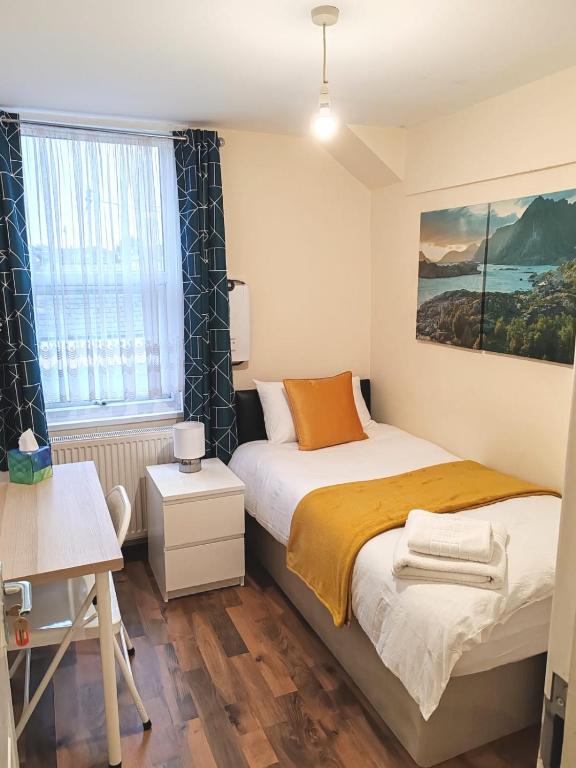 a small bedroom with a bed and a window at Cosy Single Room near Heathrow Airport in Hounslow