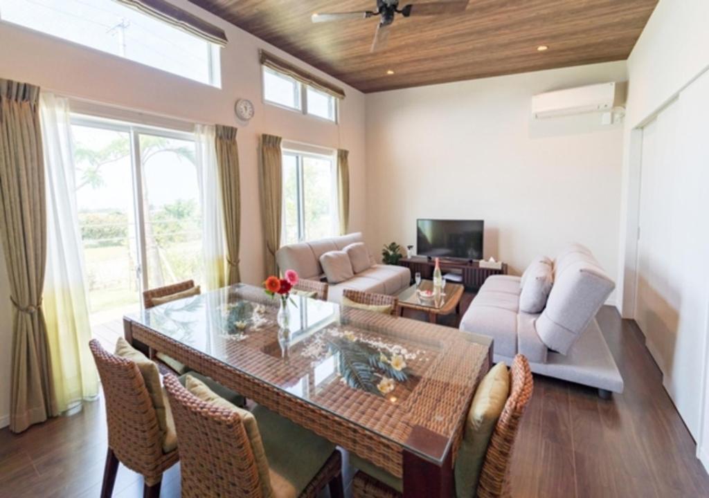 a living room with a table and chairs and a couch at BEVERLY HILLS VILLA Miyakojima Resort in Miyako-jima