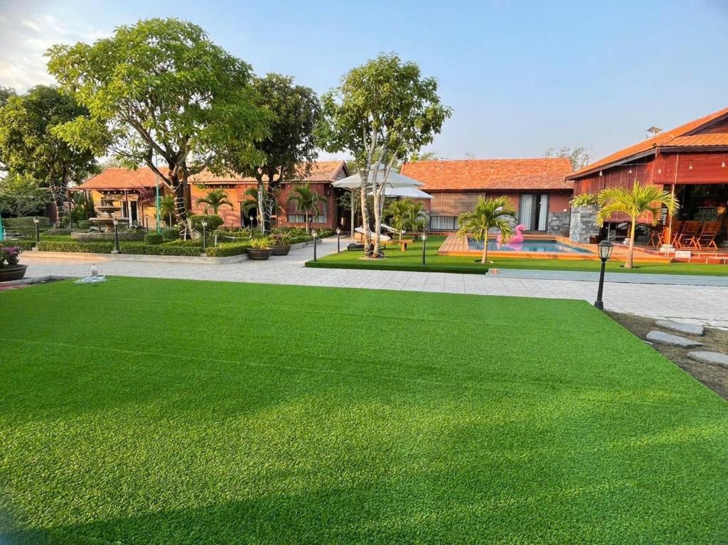 a green lawn in front of a building at Melalueca tay ninh in Tây Ninh