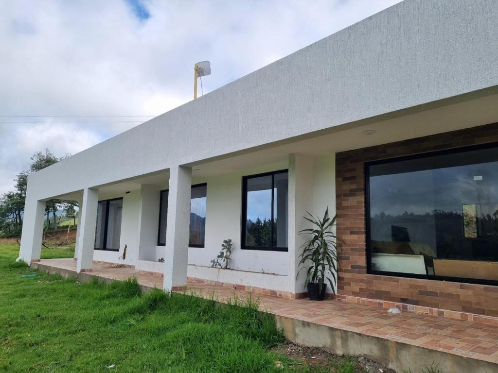 a house with a row of windows on the side of it at "Refugio campestre familiar - Cálido, cómodo y totalmente equipado" y zona de juegos in Nariño