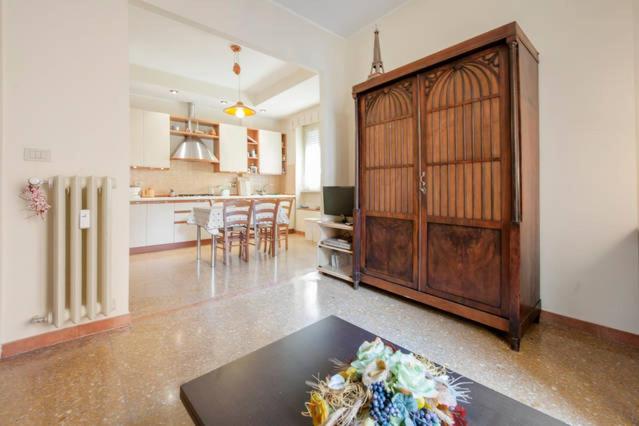 a living room with a large wooden cabinet and a kitchen at Casa Lorenzo Magnifico in Rome