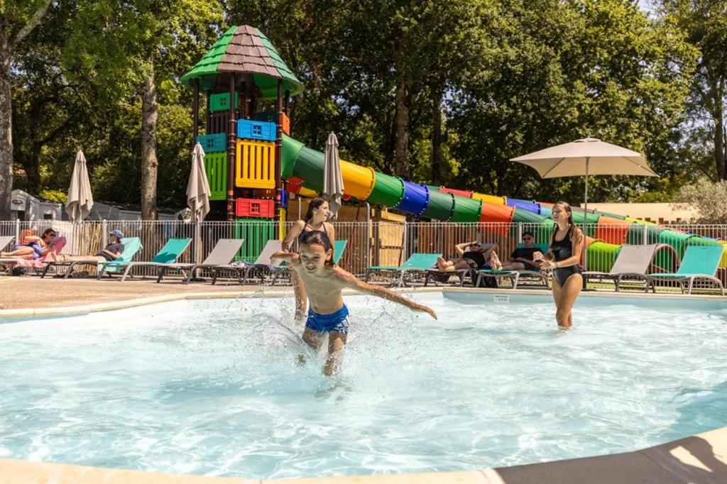 a group of people playing in a swimming pool at ZEcamping 4 étoiles 4km plage parc aquatique fitness dog friendly club enfant in Saint-Sulpice-de-Royan
