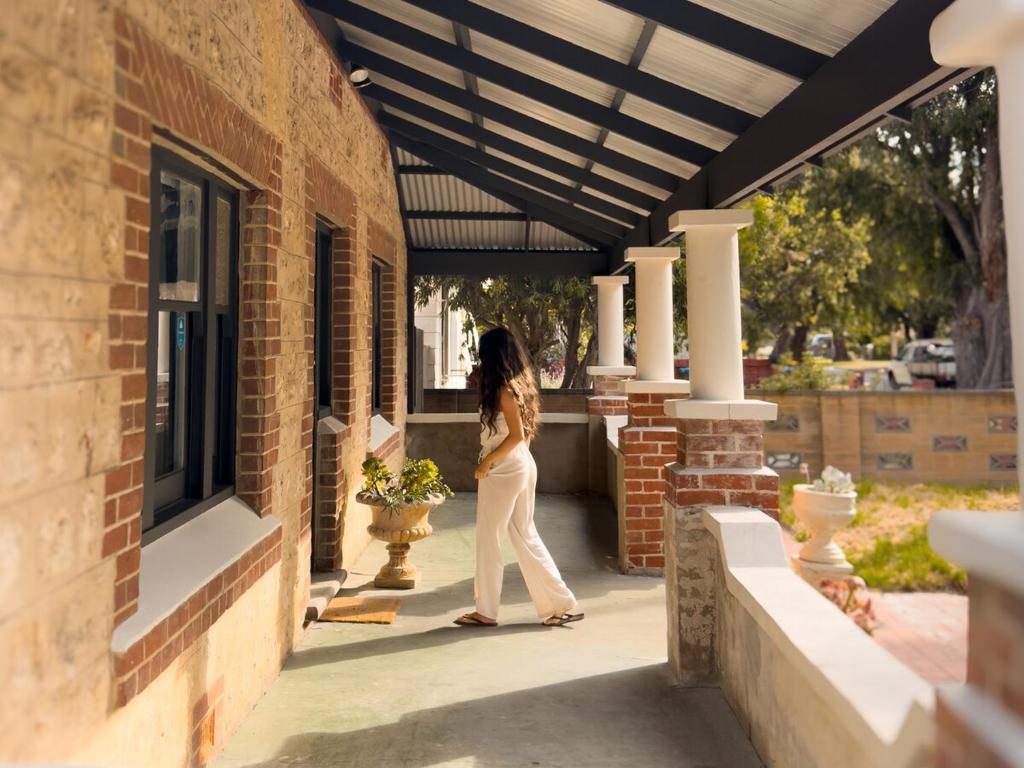 a woman walking on a porch of a building at Forrest House Victor Harbor in Victor Harbor