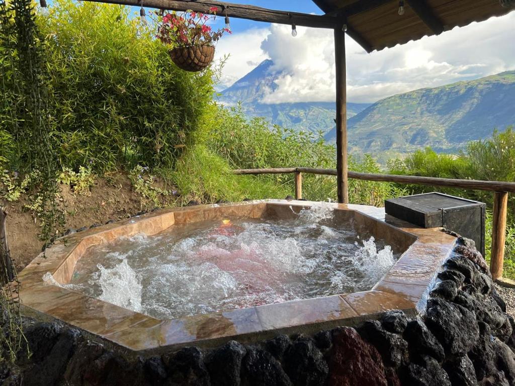 a hot tub with water in a stone wall at Patate Heights in Hacienda El Carmen