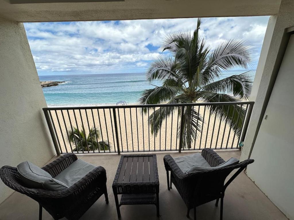 a balcony with chairs and a view of the ocean at 305 On the Beach in Waianae