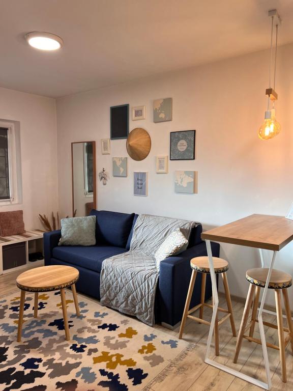 a living room with a blue couch and a table at Transylvanian Nomad II in Cluj-Napoca