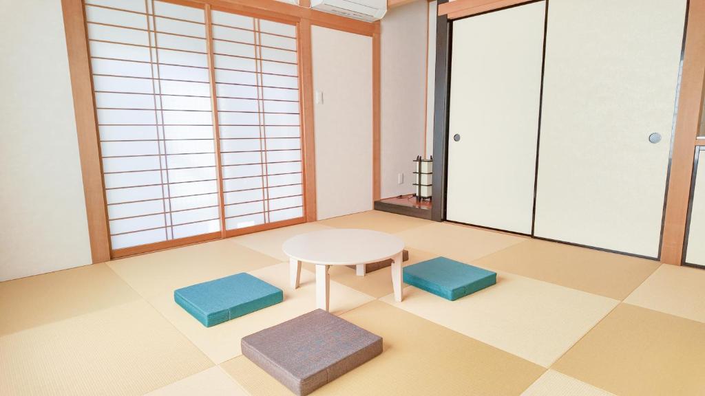 a room with a table and two stools at 9Stay市原 in Ichihara
