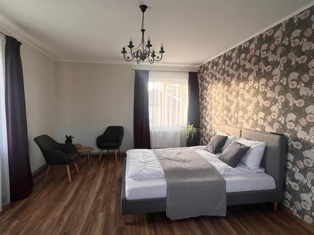 a bedroom with a bed and a chandelier at Viduma apartamenti in Ventspils
