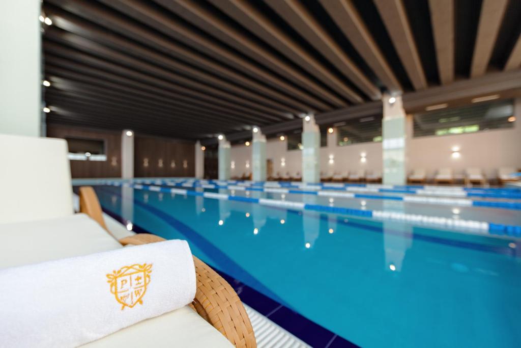 een groot zwembad met stoelen ervoor bij Premium Wellness Institute in Boekarest