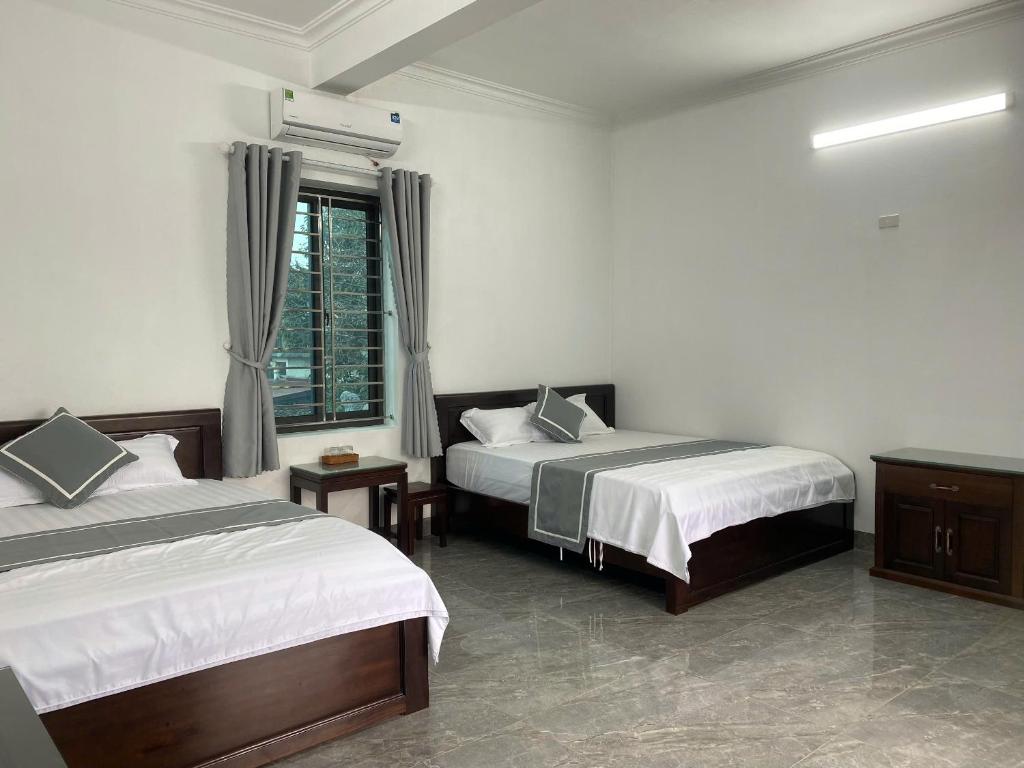a hotel room with two beds and a window at Your Home in Vũ Lâm