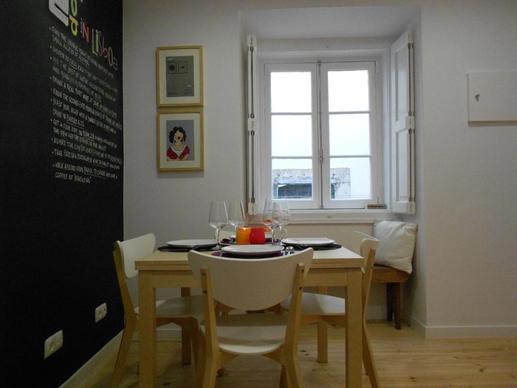 d'une salle à manger avec une table, des chaises et une fenêtre. dans l'établissement Apartamento Alfama 28, à Lisbonne