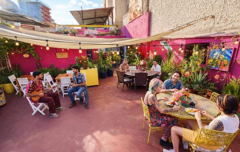 a group of people sitting at tables in a restaurant at Free Spirit Experience Guadalajara Centro in Guadalajara