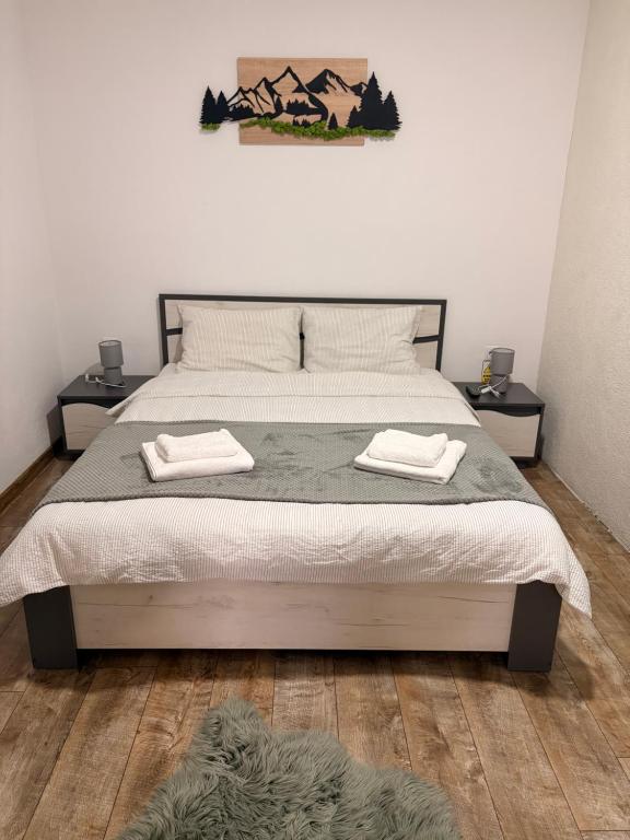 a bedroom with a bed with two towels on it at Casa Orhideea in Borsec