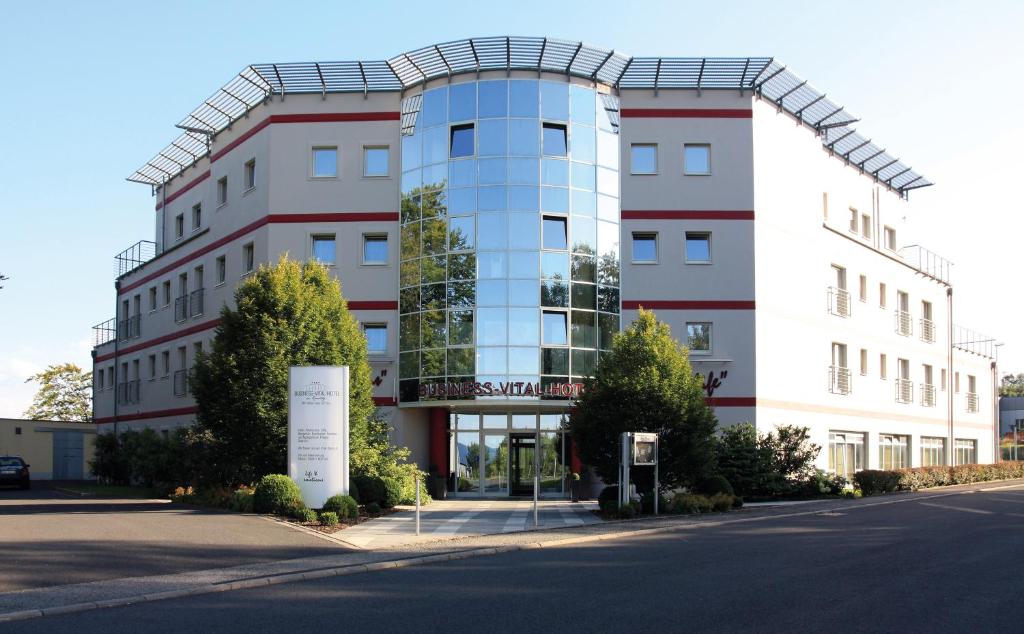 a large building with a sign in front of it at Business Vital Hotel am Rennsteig in Suhl