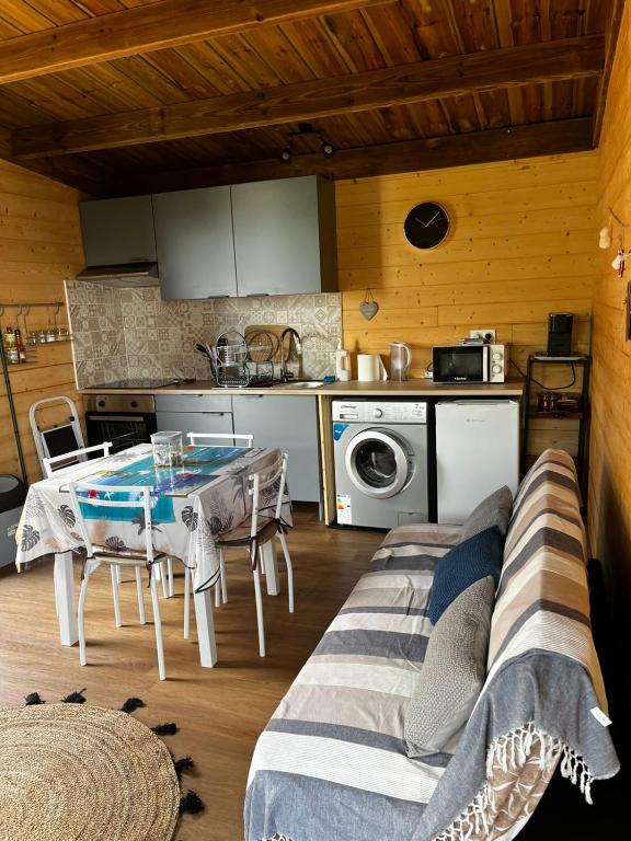 a living room with a table and a kitchen at Les chalets de la mare in Entre-Deux
