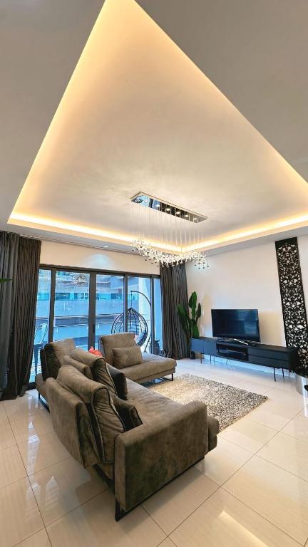 a living room with a couch and a television at 3BR family friendly Apartment at The Elements Ampang Kuala Lumpur in Kuala Lumpur