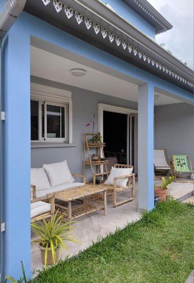 a patio with a couch and a bench on a house at Ti Kaz Salazie 2 in Salazie