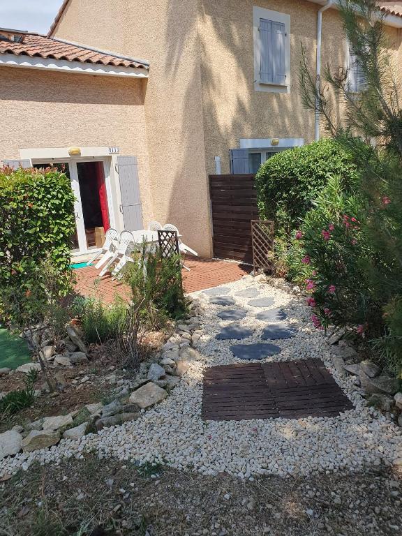a house with a patio with a table and chairs at Maison blanche in Calvisson